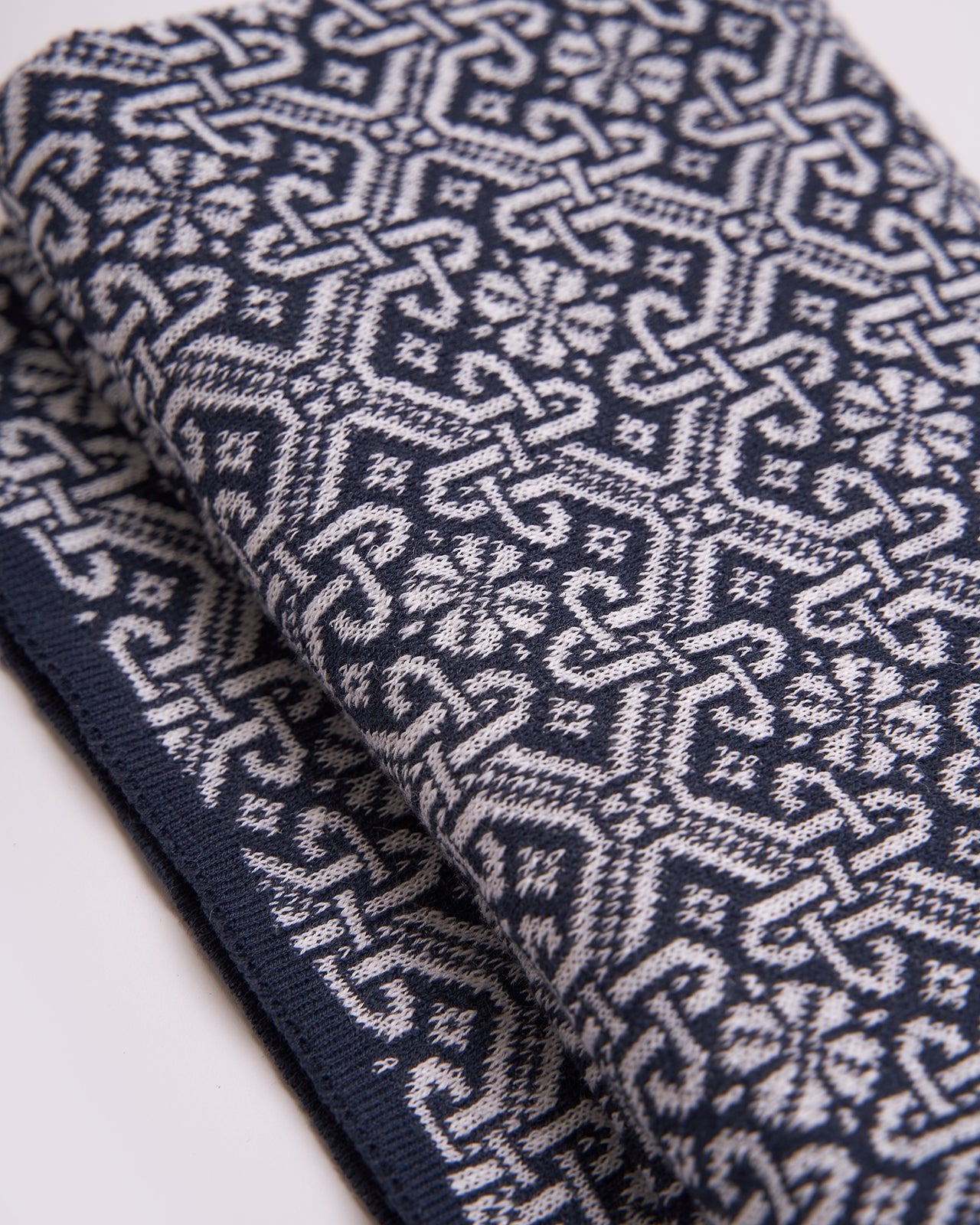 elegant navy blue scarf with a detailed brown geometric pattern and solid brown edges